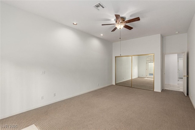 unfurnished bedroom with light colored carpet, a closet, and ceiling fan