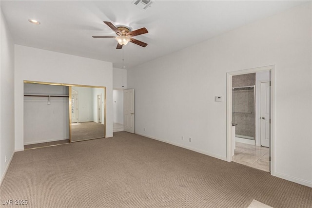 unfurnished bedroom with light colored carpet, a closet, ceiling fan, and ensuite bathroom