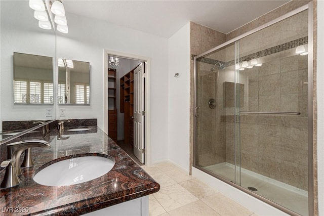 bathroom featuring a shower with door and vanity