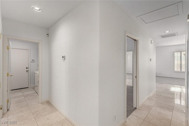 corridor with light tile patterned flooring and washer and clothes dryer