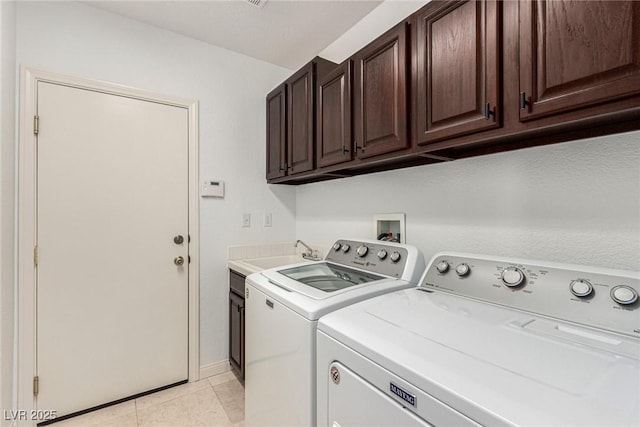 laundry room with cabinets, sink, washing machine and dryer, and light tile patterned floors