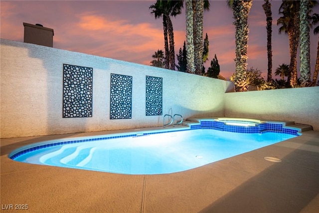 pool at dusk with an in ground hot tub