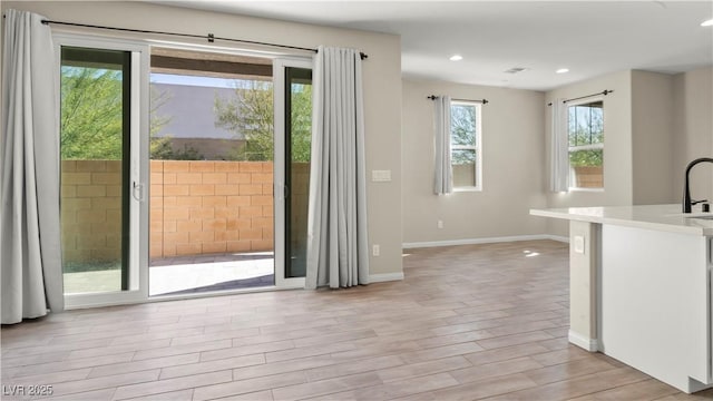 doorway featuring sink and light hardwood / wood-style flooring
