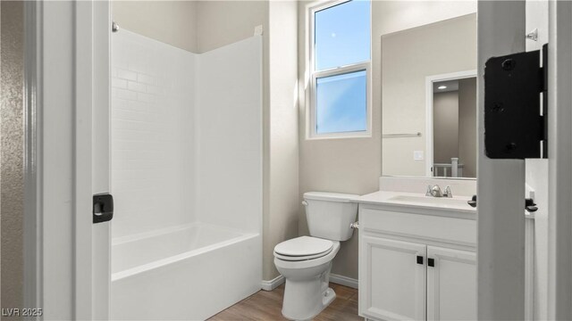 full bathroom featuring vanity, hardwood / wood-style floors, bathing tub / shower combination, and toilet