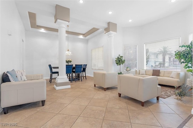 tiled living room featuring decorative columns and a towering ceiling