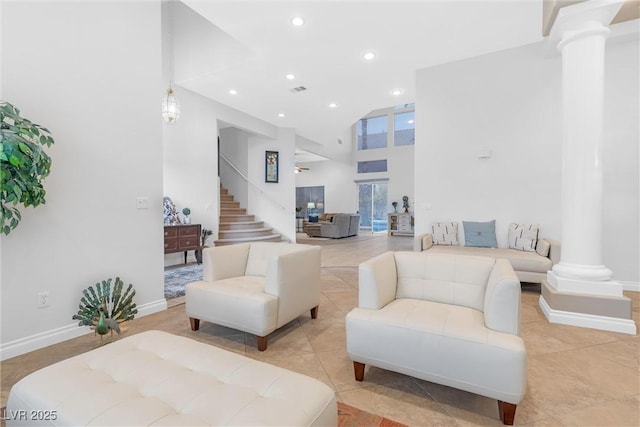 tiled living room featuring high vaulted ceiling and ornate columns