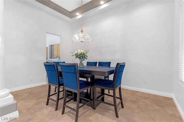 tiled dining room featuring a chandelier and a high ceiling