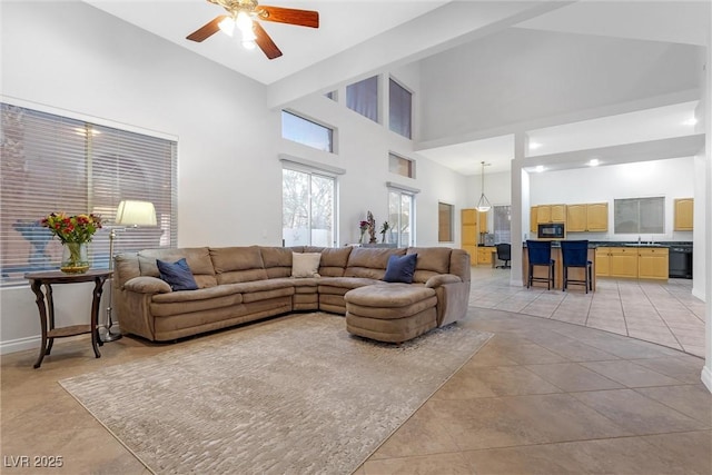 living room featuring light tile patterned flooring, sink, ceiling fan, and high vaulted ceiling