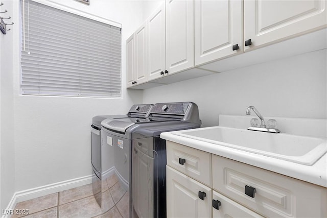 clothes washing area with cabinets, separate washer and dryer, sink, and light tile patterned floors