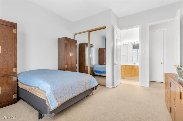 bedroom with connected bathroom, light colored carpet, and a closet