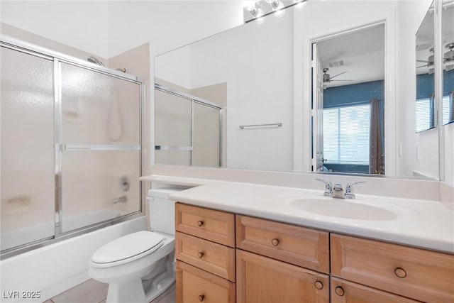 full bathroom featuring combined bath / shower with glass door, tile patterned flooring, vanity, ceiling fan, and toilet