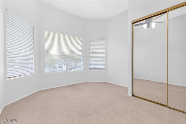 unfurnished bedroom featuring light carpet and a closet