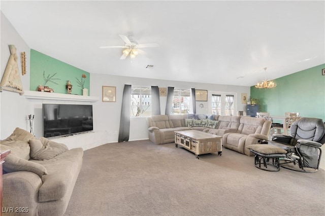 living room featuring ceiling fan with notable chandelier and carpet floors