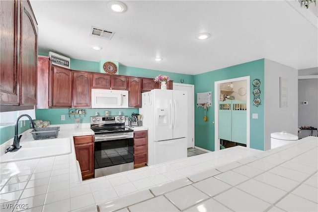 kitchen with white appliances, tile countertops, and sink