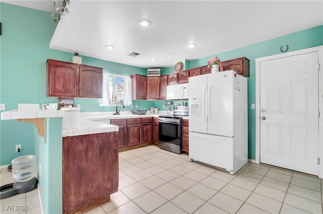 kitchen with light tile patterned flooring, white appliances, kitchen peninsula, and sink