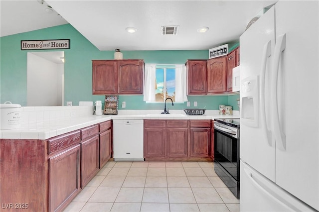 kitchen featuring sink, white appliances, kitchen peninsula, and light tile patterned flooring