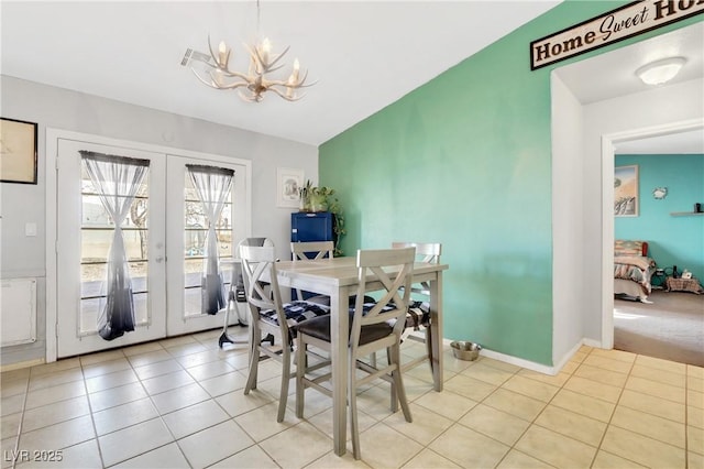 dining area featuring french doors, vaulted ceiling, an inviting chandelier, and light tile patterned floors