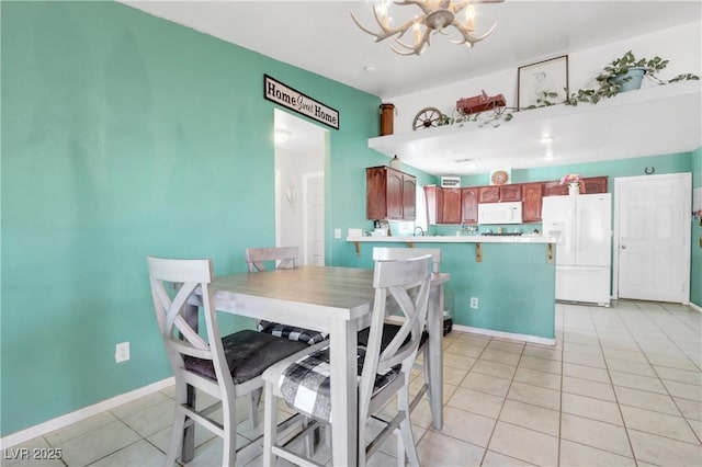 tiled dining room with a chandelier