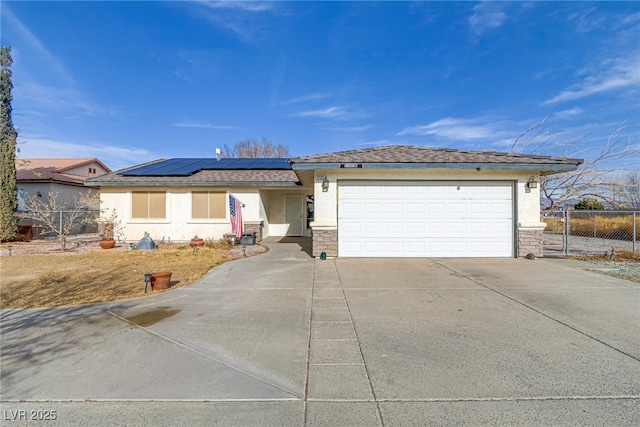 ranch-style home with a garage and solar panels