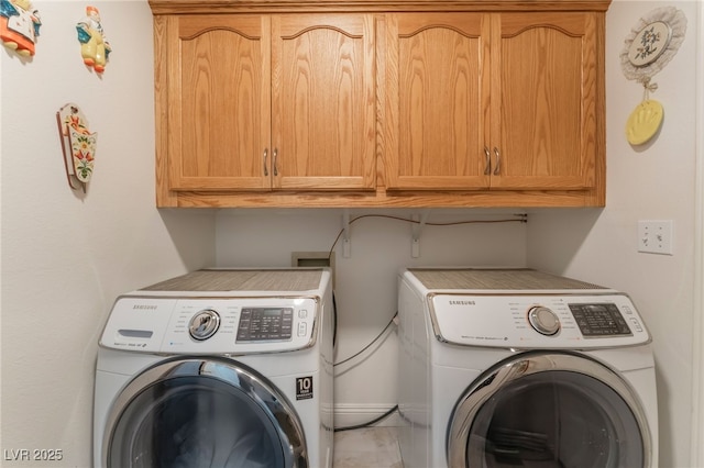 washroom with washer and dryer and cabinet space