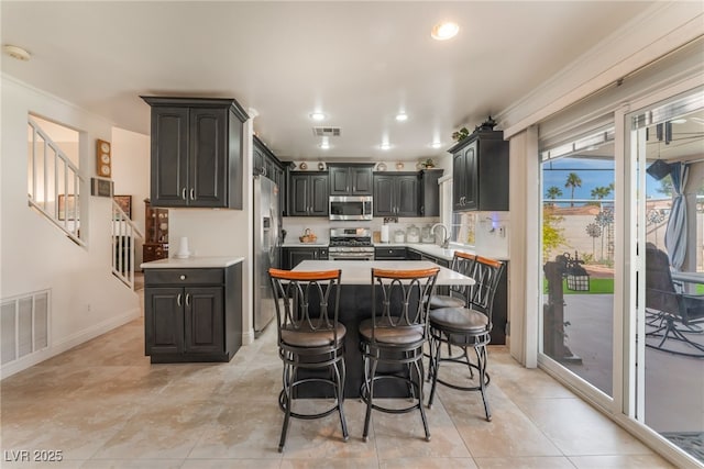 kitchen with light countertops, visible vents, appliances with stainless steel finishes, and a center island