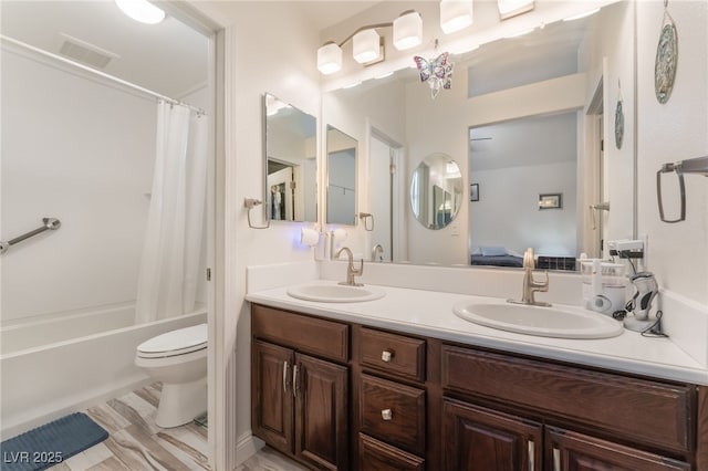 ensuite bathroom featuring double vanity, toilet, visible vents, and a sink