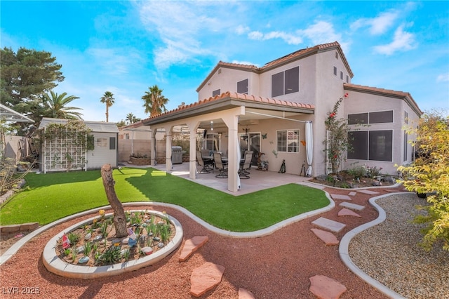 rear view of property with a patio, fence, stucco siding, an outdoor structure, and a tiled roof