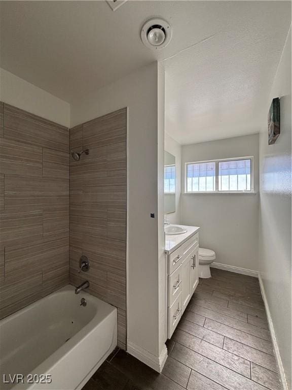 full bath featuring shower / bath combination, baseboards, toilet, and vanity