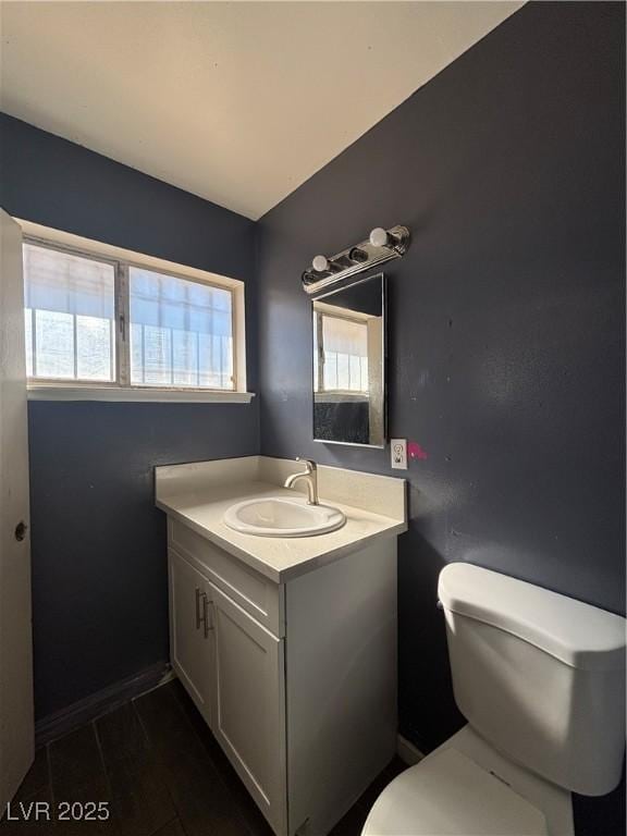 bathroom with vanity, toilet, and baseboards