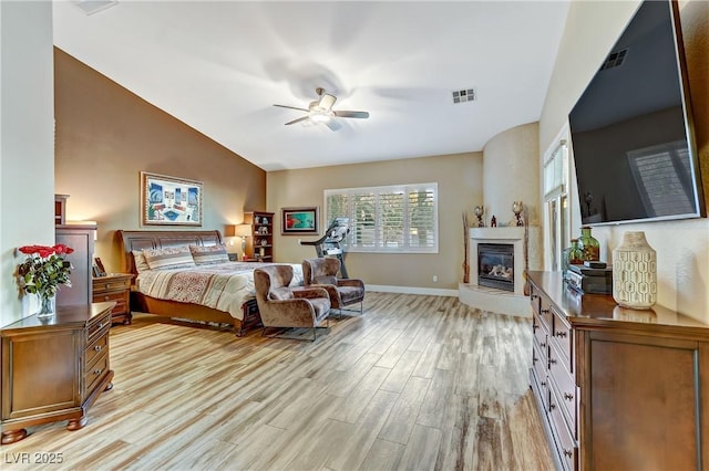 bedroom with ceiling fan, lofted ceiling, and light hardwood / wood-style floors