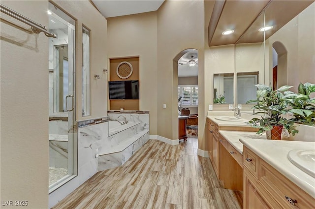 bathroom with hardwood / wood-style flooring, ceiling fan, vanity, and independent shower and bath