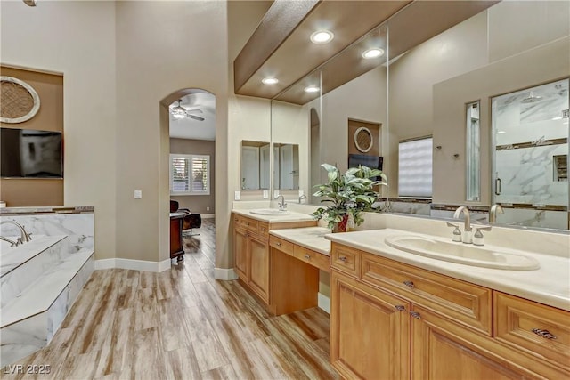 bathroom featuring vanity, ceiling fan, wood-type flooring, and separate shower and tub