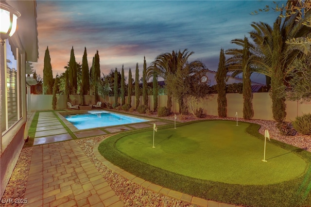 pool at dusk featuring a patio area