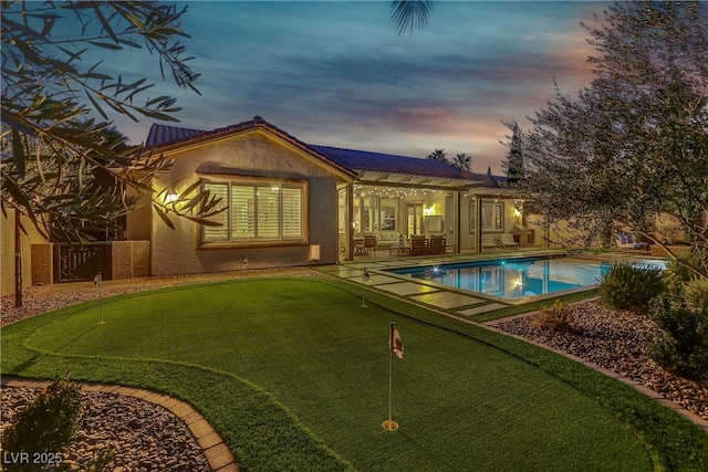 pool at dusk featuring a patio