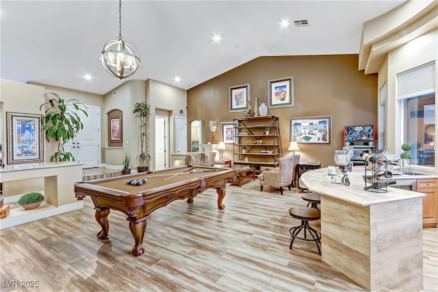 rec room with billiards, high vaulted ceiling, and light hardwood / wood-style floors