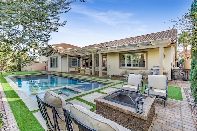 view of swimming pool featuring area for grilling, an outdoor living space with a fire pit, a patio, and an in ground hot tub