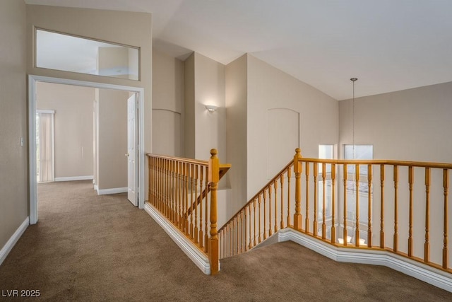 hallway featuring carpet and high vaulted ceiling