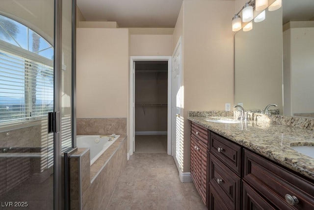 bathroom with vanity and tiled tub