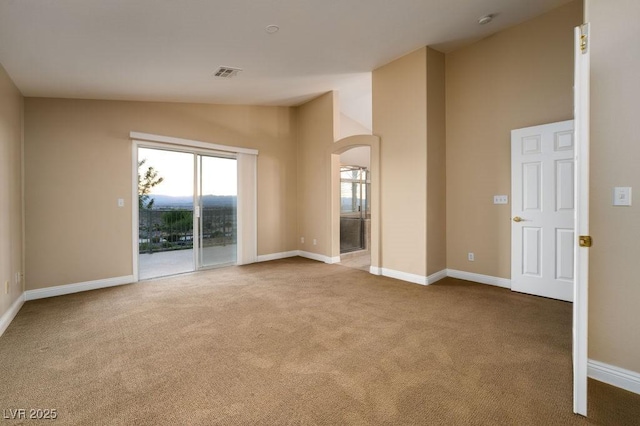 spare room featuring carpet and high vaulted ceiling