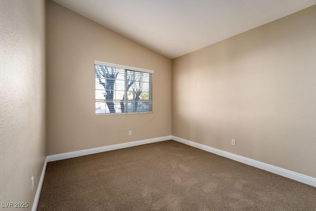 carpeted empty room featuring lofted ceiling