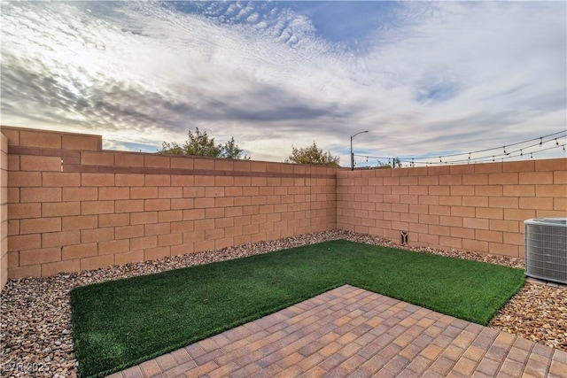 view of yard with central AC unit and a patio area