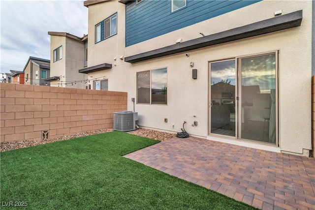 rear view of house featuring central AC, a patio area, and a lawn