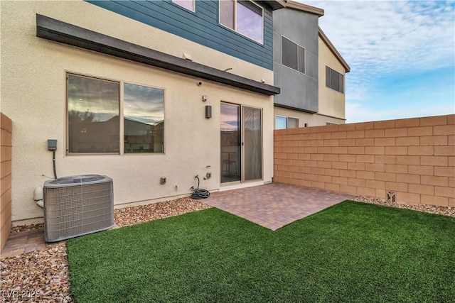 back of property featuring cooling unit, a patio, and a lawn