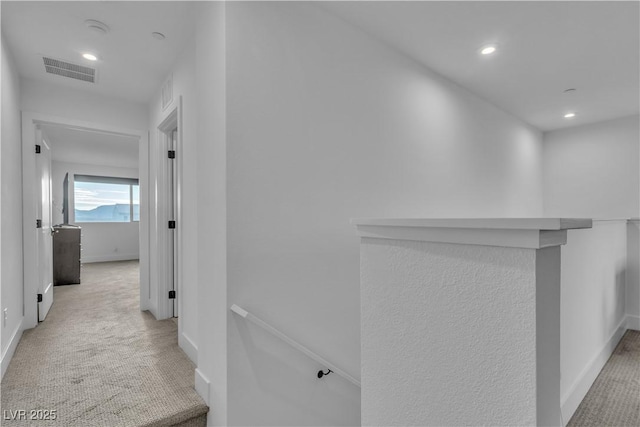 hallway featuring light colored carpet