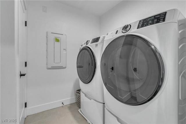 clothes washing area featuring electric panel and washer and dryer