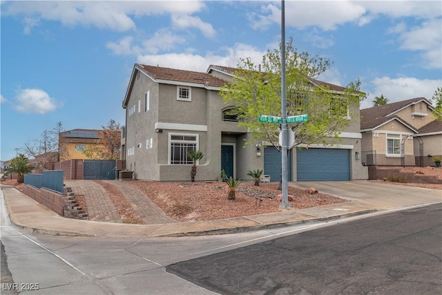 view of front facade featuring driveway, central AC unit, an attached garage, fence, and stucco siding