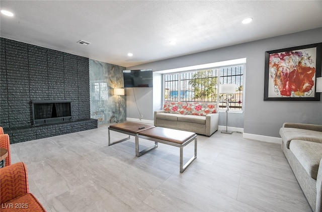 living room with a fireplace and a textured ceiling