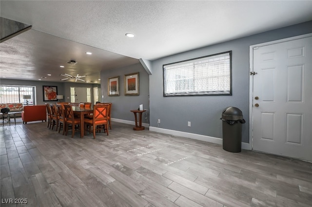 dining area with a textured ceiling and light wood-type flooring