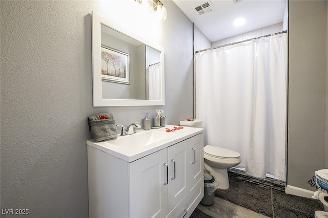 bathroom featuring vanity, hardwood / wood-style floors, and toilet