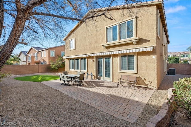 back of property with central AC and a patio